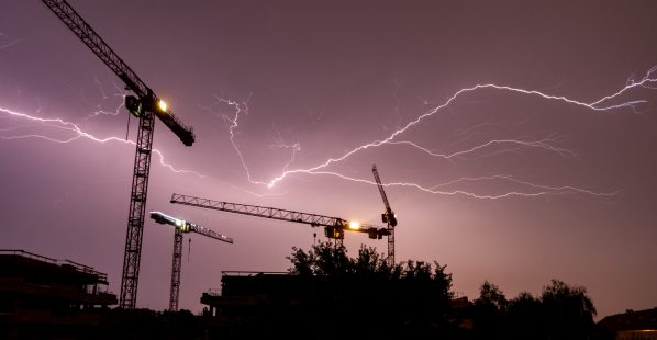 Lightning,Strikes,Behind,The,Cranes,Of,A,Construction,Site,In